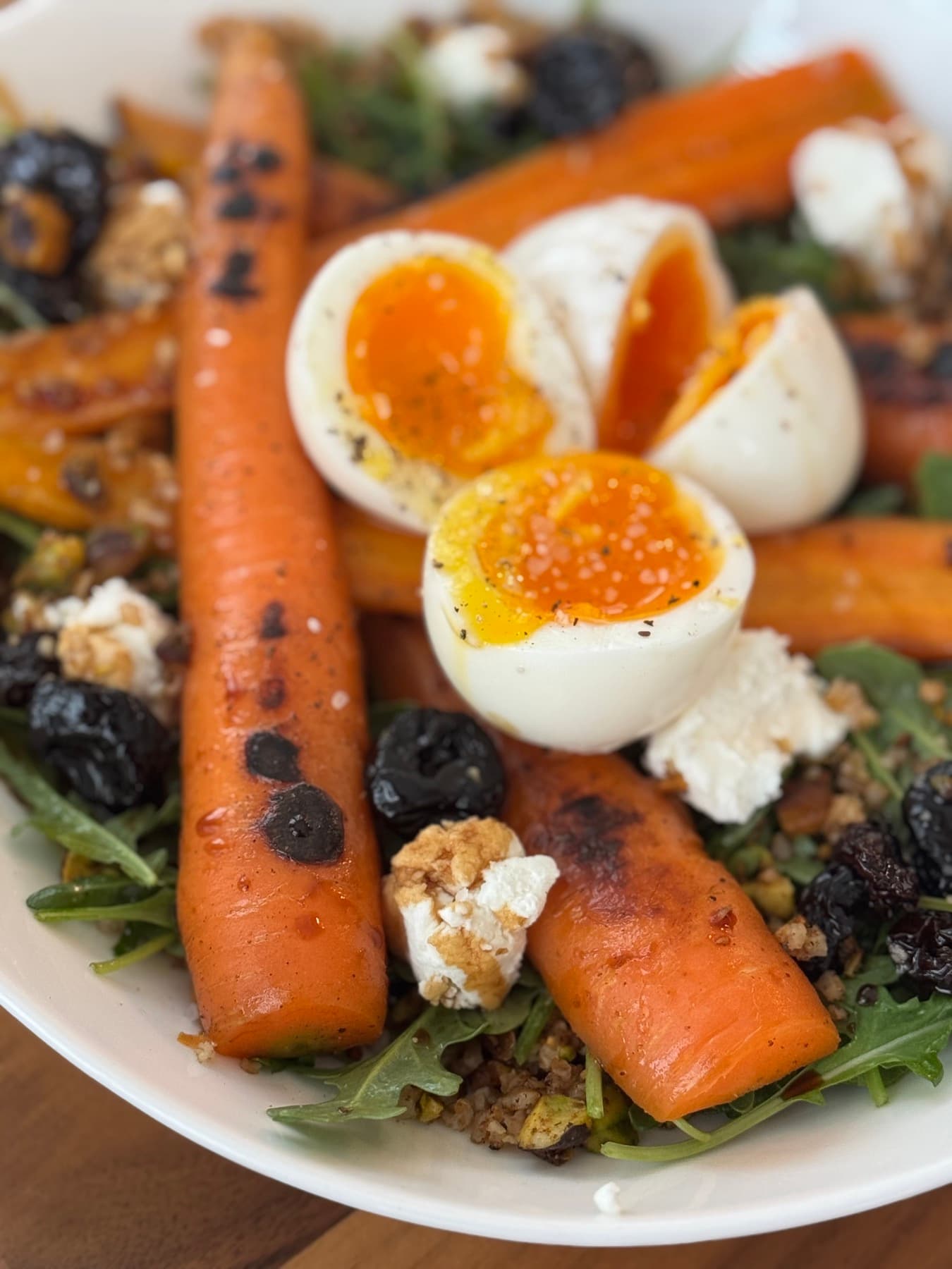 Grain bowl with charred carrots, soft eggs, and arugula