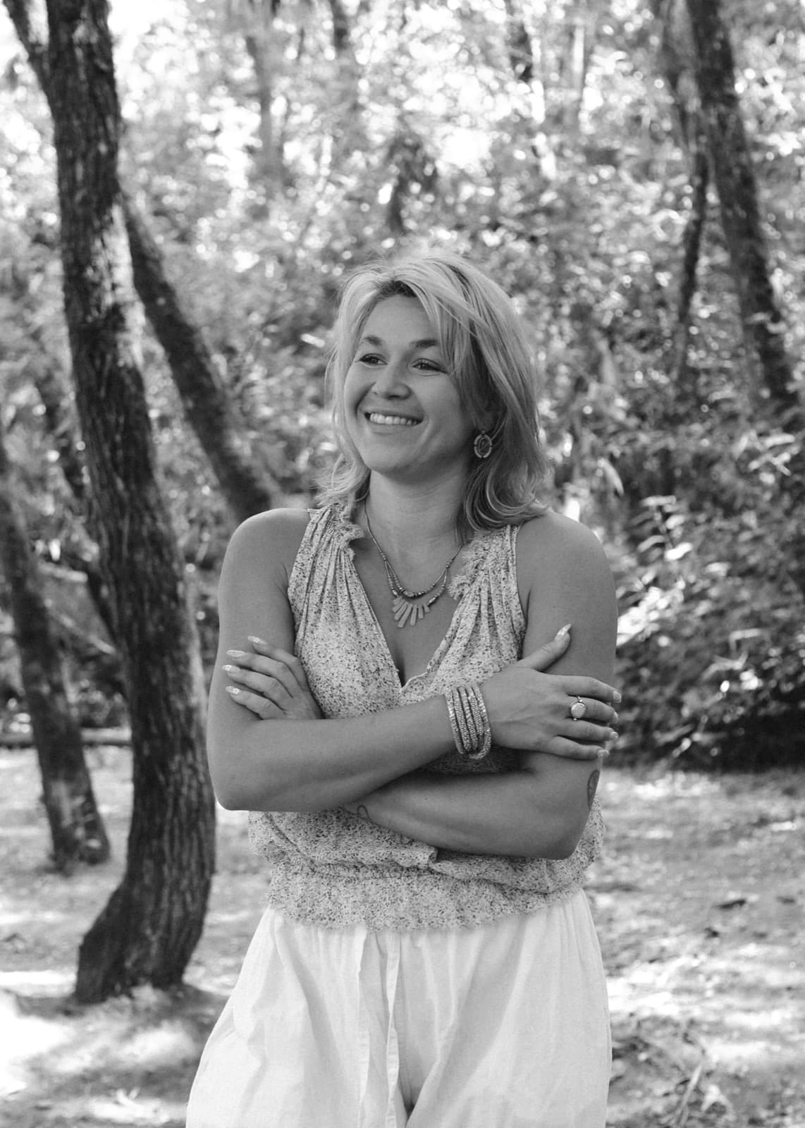 Sarah West, smiling, photographed outdoors in black and white